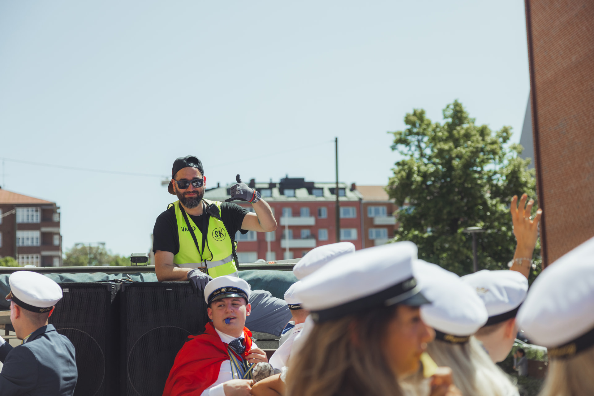 Flakvärd med varselväst och kommunikationsradio på ett studentflak